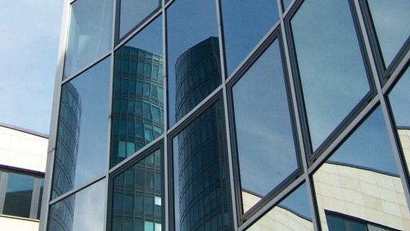 Titel der Produktbroschüre BauStatik - Glasbau. Zu sehen ist eine Glasfassade.